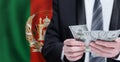 Hands holding dollar money on flag of Afghanistan Royalty Free Stock Photo