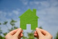 Hands holding eco house icon concept on the blue sky background Royalty Free Stock Photo