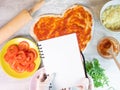 Hands holding empty note pad on pizza ingredient and basis on background Royalty Free Stock Photo