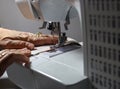 Hands holding fabric while operating a sewing machine - selective focus & motion Royalty Free Stock Photo