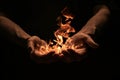 Hands holding fire in dark background. Powerful and magical concept image with warm tones. Suitable for creative Royalty Free Stock Photo