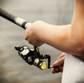 Hands holding a fishing rod and twist the handle of the fishing Royalty Free Stock Photo