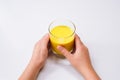 Hands holding glass of golden milk turmeric latte  on white background Royalty Free Stock Photo