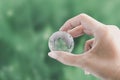 Hands holding globe glass earth with green grass field in side on blurred light nature background. Environment Concept Royalty Free Stock Photo