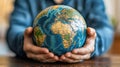 Hands holding a globe, representing world peace or environmental concern, at home Royalty Free Stock Photo