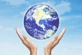 Hands holding globe with sky background Royalty Free Stock Photo