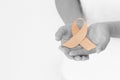 Hands holding gold ribbon on white background with copy space. The international awareness symbol for Childhood Cancer. World Royalty Free Stock Photo