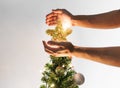 Hands holding golden star on Christmas tree with bright lights, Christmas holiday concept Royalty Free Stock Photo