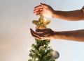 Hands holding golden star on Christmas tree with bright lights, Christmas holiday concept Royalty Free Stock Photo