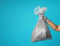 Hands holding gray garbage bags on blue background Royalty Free Stock Photo