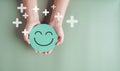 Hands holding green happy smile face, good feedback rating, positive customer review, experience, satisfaction survey, smiley Royalty Free Stock Photo