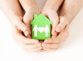 Hands holding green house with family Royalty Free Stock Photo