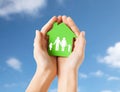 Hands holding green house with family pictogram Royalty Free Stock Photo