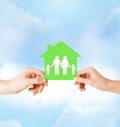 Hands holding green house with family Royalty Free Stock Photo