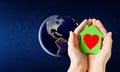 Hands holding green house over earth in space Royalty Free Stock Photo