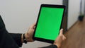 Hands holding green tablet template in office closeup. Employee video calling