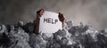The Hands Holding a Help Sign Amidst a Sea of Crumpled Paper AI generated image Royalty Free Stock Photo