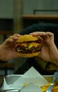 Hands holding homemade beef grill bacon cheese with salad hamberger and French fries