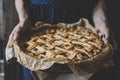 Hands holding homemade delicious apple pie. Close up