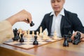 Hands holding horse while playing chess against background of man Royalty Free Stock Photo