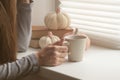 Hands holding hot cup of coffee or tea in morning sunlight, Beautiful romantic unrecognizable girl drinking hot beverage at cozy h Royalty Free Stock Photo