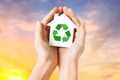 Hands holding house with green recycling sign Royalty Free Stock Photo