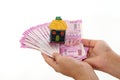 Hands holding Indian currency with house shape Royalty Free Stock Photo