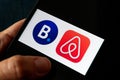 Hands holding iPhone 11 with Airbnb and booking.com service icons. Royalty Free Stock Photo