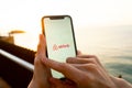 Hands holding iPhone 11 with an app of airbnb service. Holidays and vacation concept.