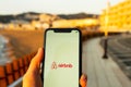Hands holding iPhone 11 with an app of airbnb service. Holidays and vacation concept.