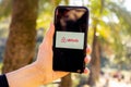 Hands holding iPhone 11 with an app of airbnb service. Holidays and vacation concept.