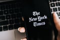 Hands holding iPhone X with The New York Times logo on the screen. Royalty Free Stock Photo