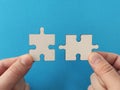 Hands holding jigsaw puzzle pieces on blue background, business success partnership or teamwork concept Royalty Free Stock Photo