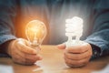 Hands holding light bulb and spiral bulb, Saving energy efficiency and accounting finance concept Royalty Free Stock Photo