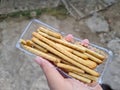 Hands holding light snacks, namely crunchy sticks, savory taste Royalty Free Stock Photo