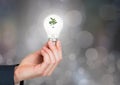 Hands holding lightbulb with green nature energy with sparkling light bokeh background Royalty Free Stock Photo