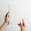 Hands holding a long rectangular object against a white background Royalty Free Stock Photo