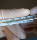 Hands holding medical thermometer