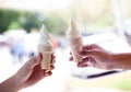 Hands holding melting ice cream waffle cone in hands on summer light nature background. Royalty Free Stock Photo
