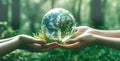 Hands holding a miniature of the Earth in a green forest setting. Ecology concept. AI-generated. Royalty Free Stock Photo