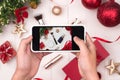 Hands holding mobile taking photo of christmas make up cosmetics products Royalty Free Stock Photo