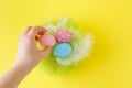 Hands holding modern painted easter egg in a small nest Royalty Free Stock Photo