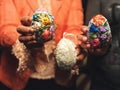 Hands holding modern painted easter eggs