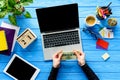 hands holding money by laptop on blue wooden table Royalty Free Stock Photo