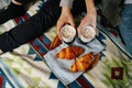 Hands holding mugs with coffee and marshmallows. Couple having breakfast in bed. Royalty Free Stock Photo