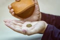 Hands holding one dollar coin and small money pouch Royalty Free Stock Photo