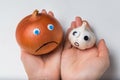 Hands holding onions and garlic on white background. Products characters with funny faces