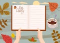 Hands holding an open Autumn Daily Diary notepad, list schedule, goals, to do, acorn, autumn leaves, coffe cup. Personal Royalty Free Stock Photo