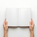 Hands holding an open book against a plain background Royalty Free Stock Photo