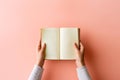 Hands holding an open book on pastel background. Reading, studying, school, diary, education, university learning, time for Royalty Free Stock Photo